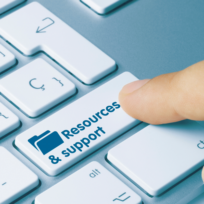 Close-up of a hand pressing a keyboard key labeled "Resources & support" alongside a folder icon.